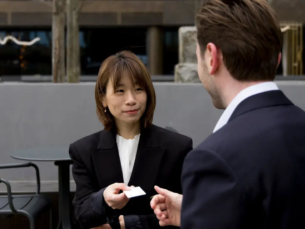 Two professionals exchanging a business card