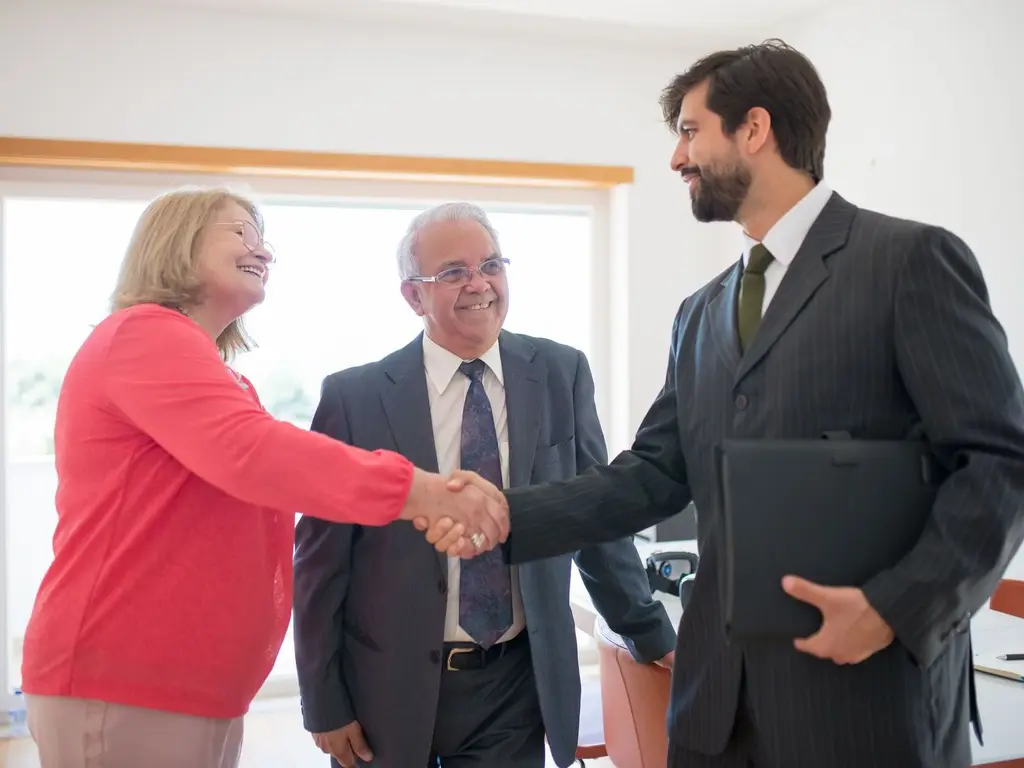 A real estate agent shaking hands with clients
